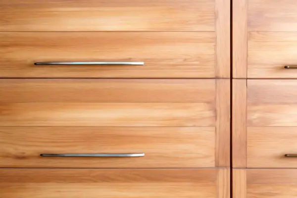 Anteprima di un mobile con cassetti in legno di frassino, con maniglie metalliche.
